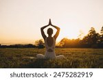 Young woman practicing yoga on nature. Girl meditating outdoors. Female with slim, strength and flexibility body. Healthy lifestyles. Concept of vitality, calmness, relax, mindfulness, zen energy.